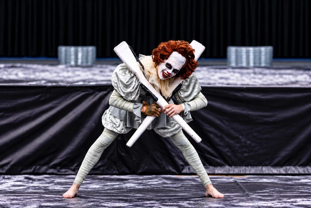 An MBI Winter Guard performer in Pennywise clown costume during the 2023 show Welcome to Derry